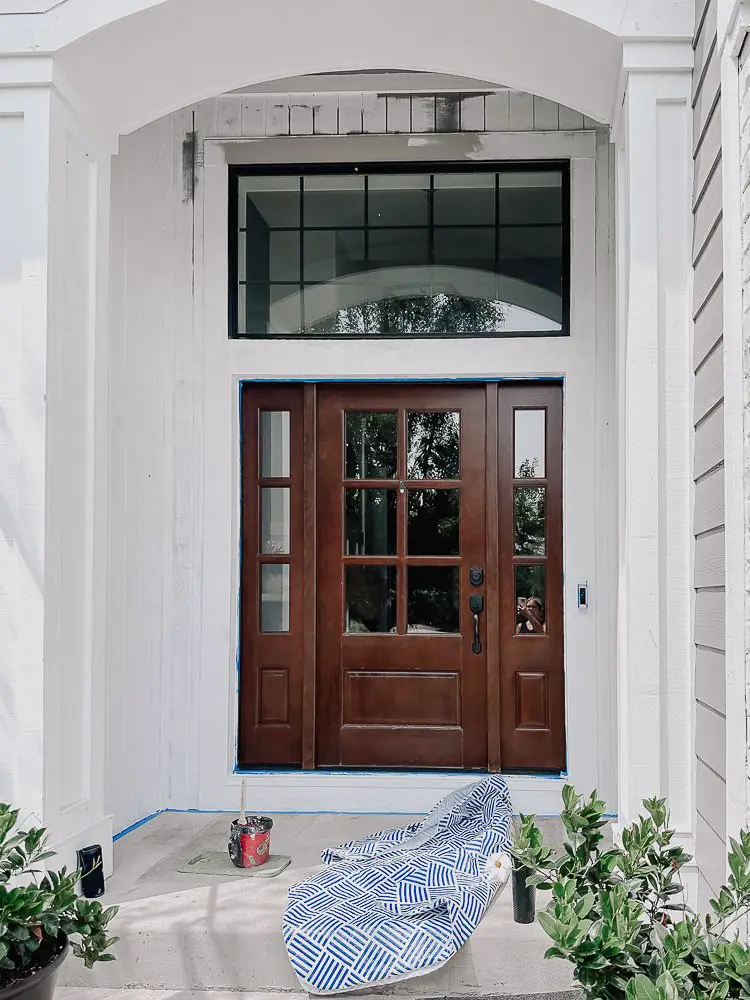 Front porch recently painted white. Wooden front door.