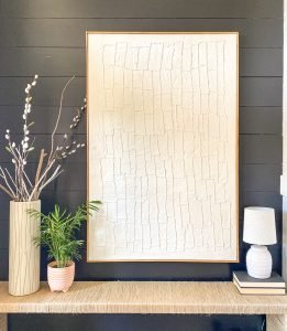 Beautiful canvas wall art on the wall with decor on a console in front of it