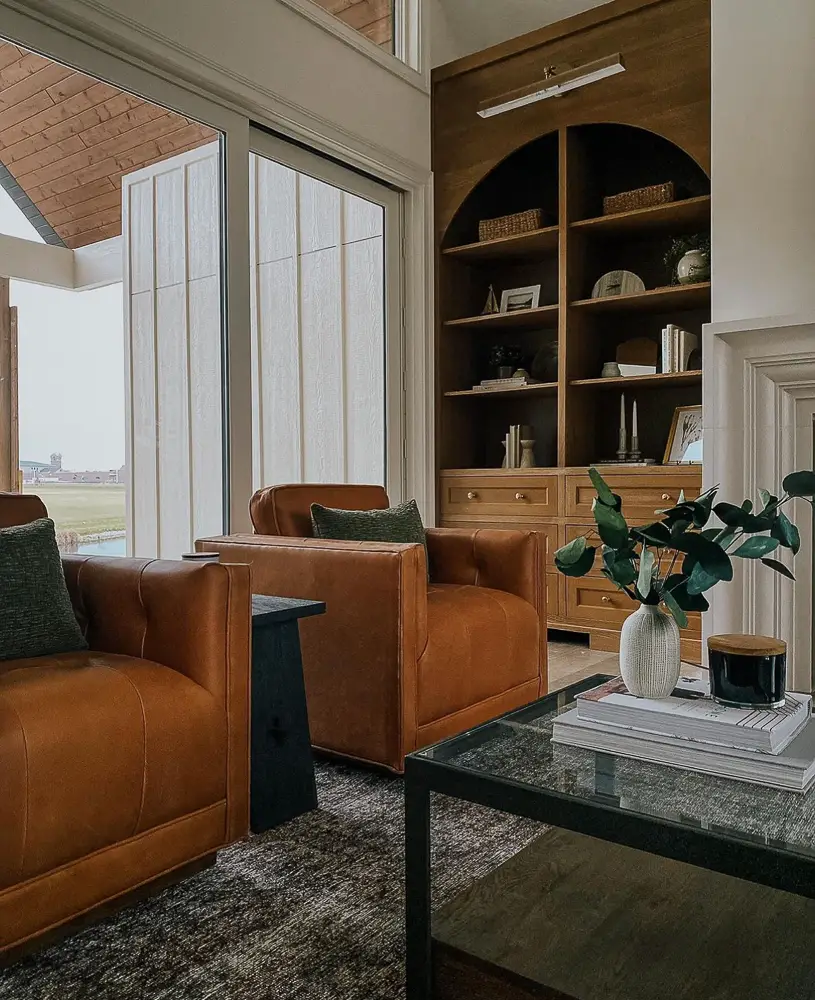 Moody room with leather matching chairs in front of large windows
