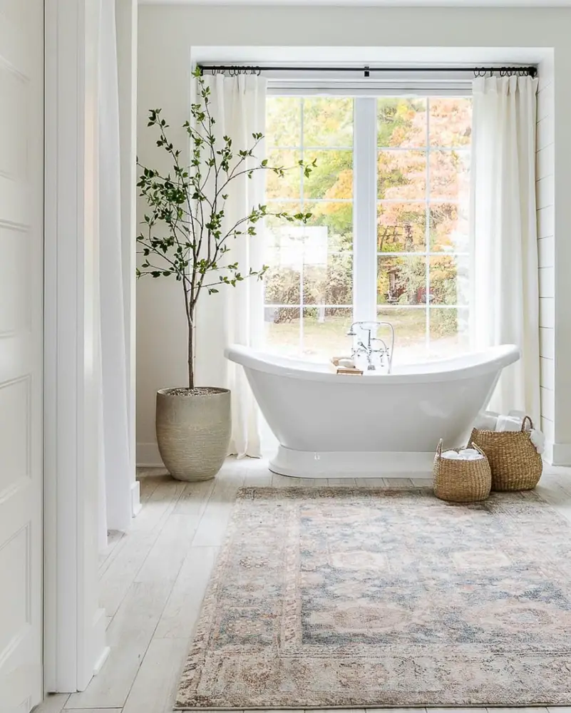 Large free standing tub in front of large windows.