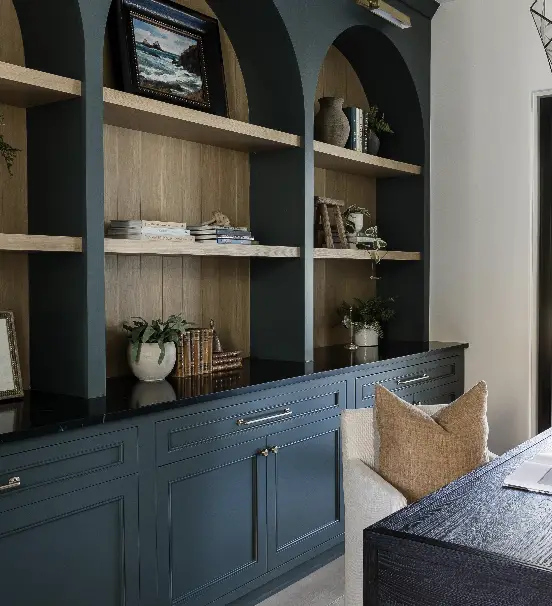 Bookshelves painted blue with stained wood backdrop.