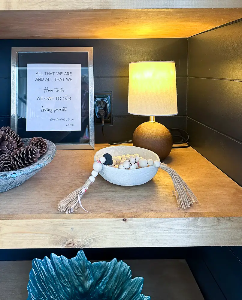 Shelf with accent light, bowl and decorative beads for decorate a bookshelf.