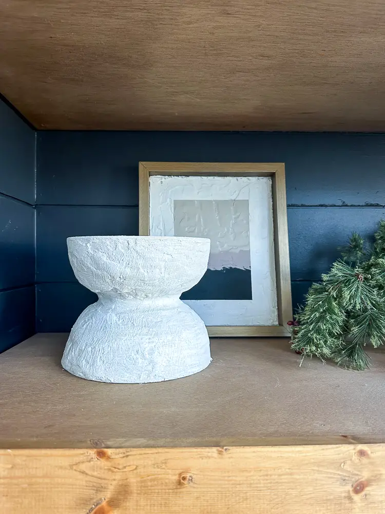 Shelf with vase and picture.