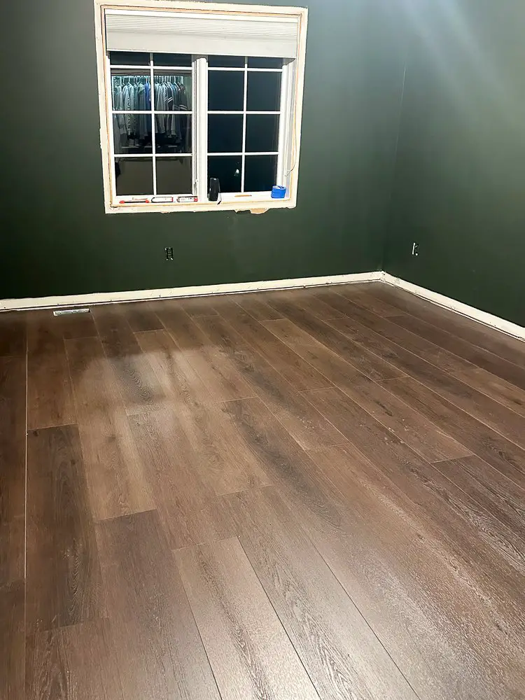 Dark wood flooring in an all deep green painted room.
