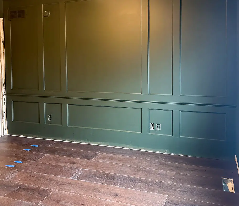 Millwork wall with dark wood floors for home office guest room reveal.