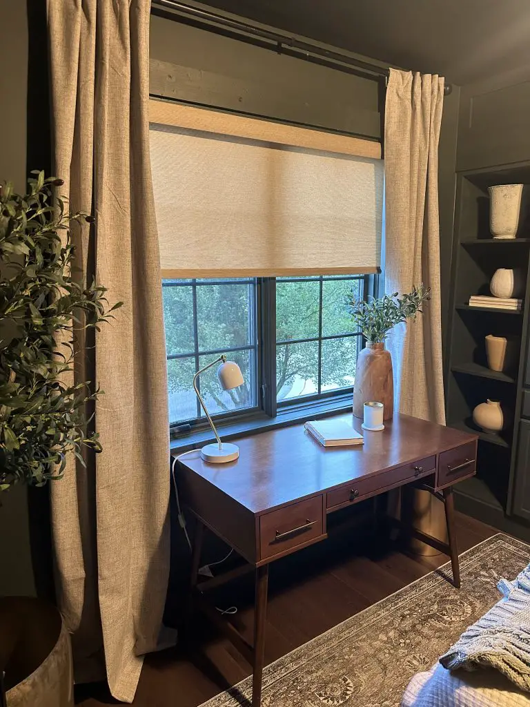 Long curtains layered with motorized shades.