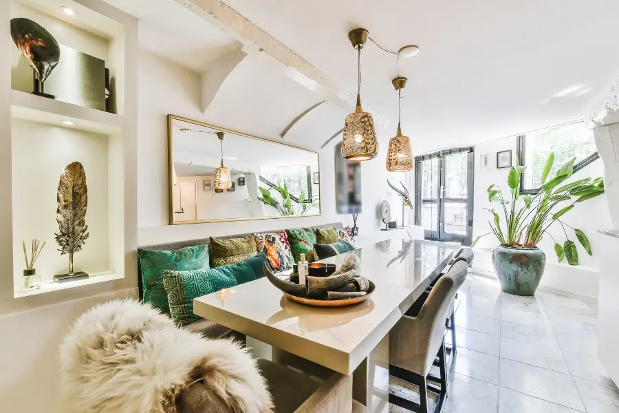 Dining area with a long table and pendant lighting.