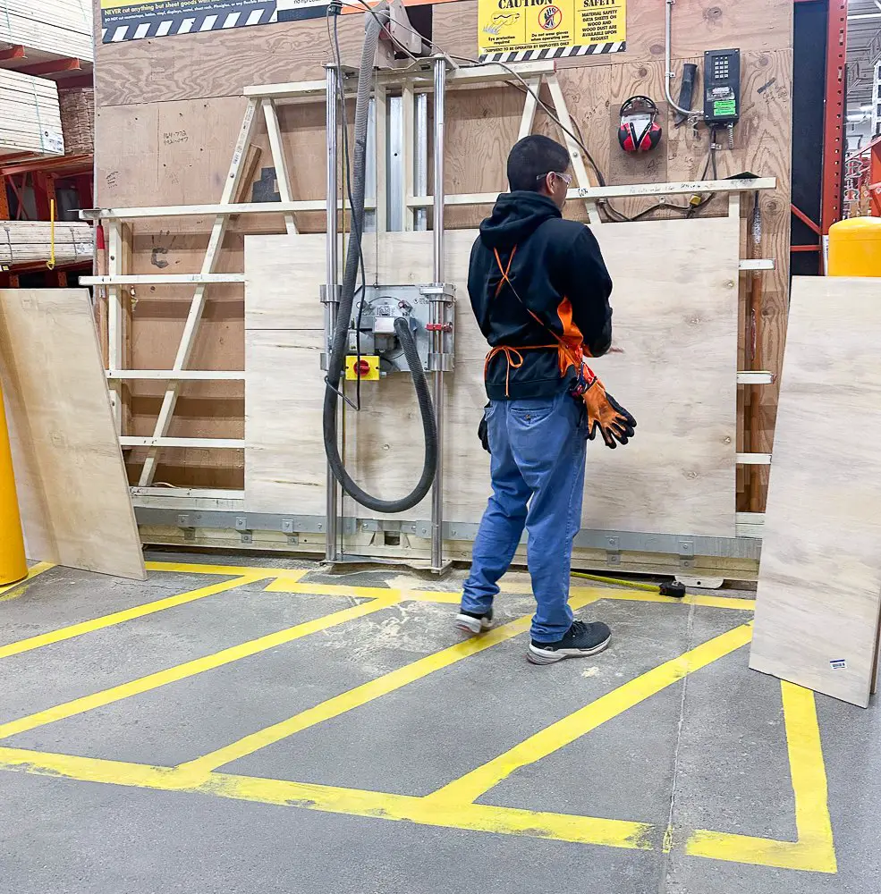 A man at Home Depot cutting wood.