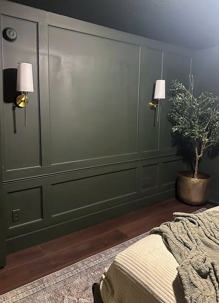 Millwork wall for a functional home office space. 2 sconces and a decorative tree.