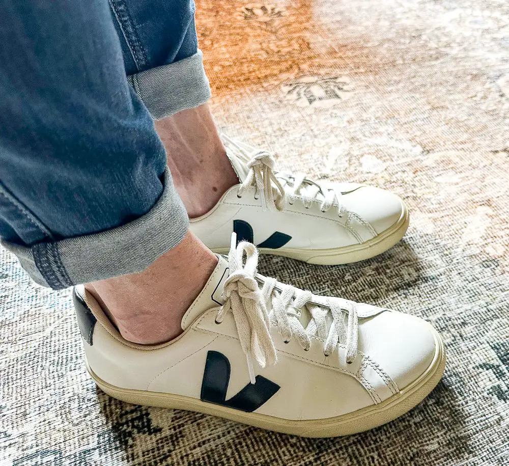 A girl wearing Veja tennis shoes.