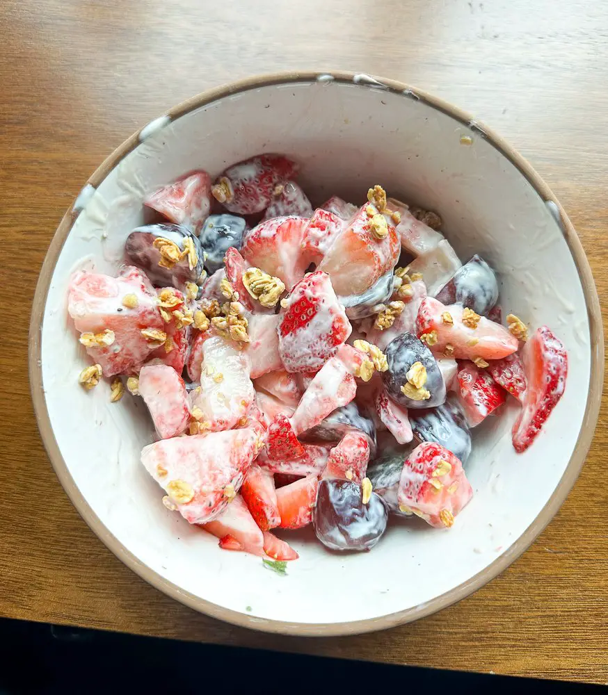 Bowl of mixed fruit with yogurt and crunch.