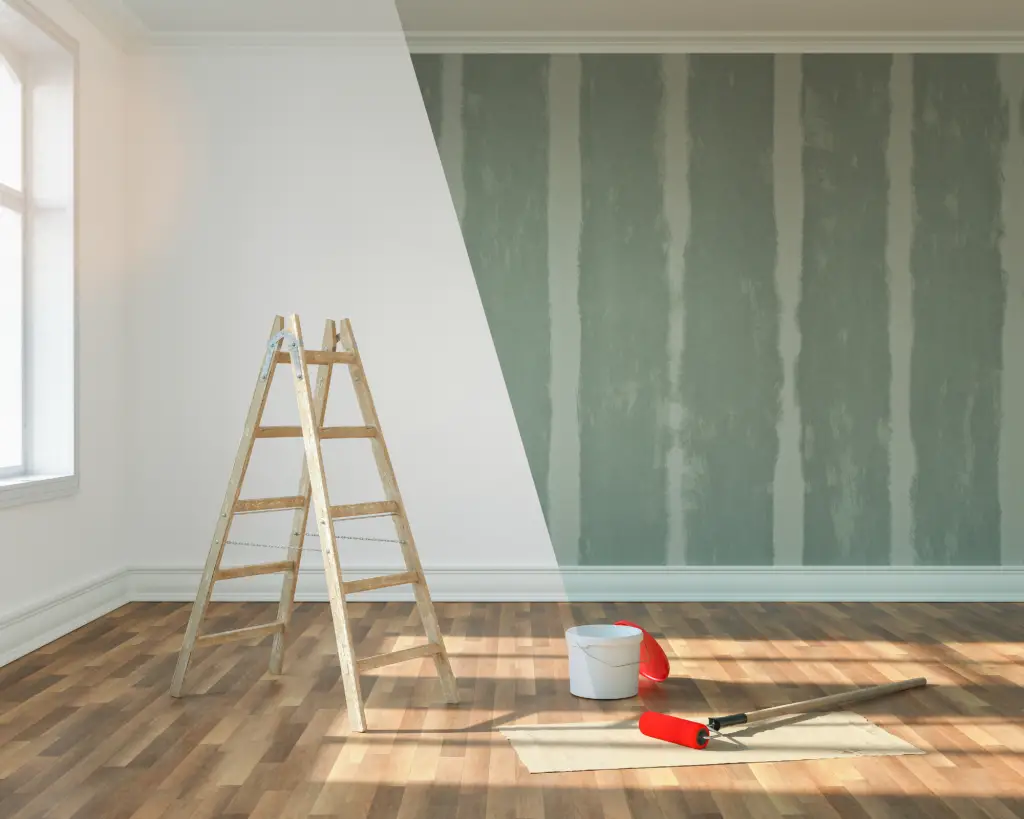 A wall being painted with a ladder in the room.