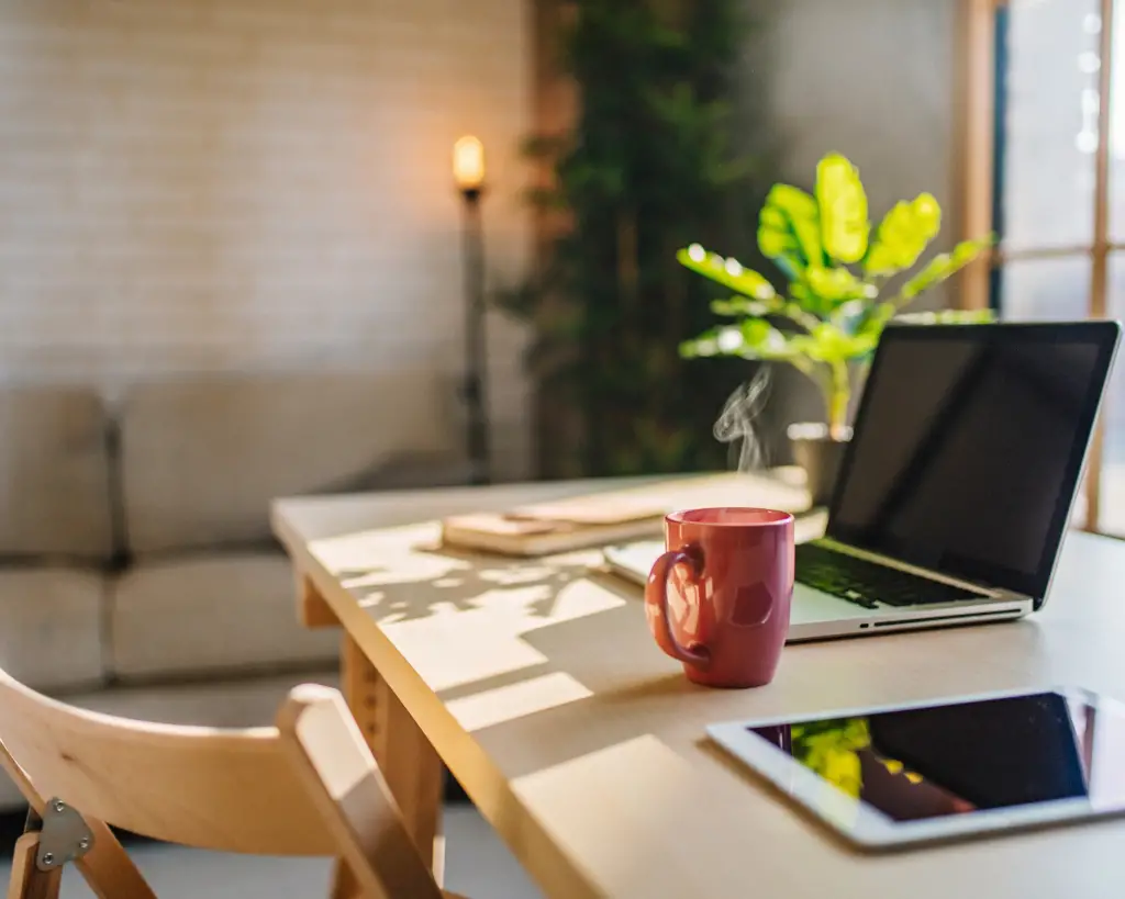 An office desk with laptop and mug.