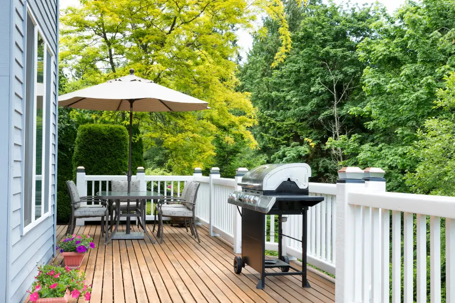 Large deck with a grill and umbrella table.