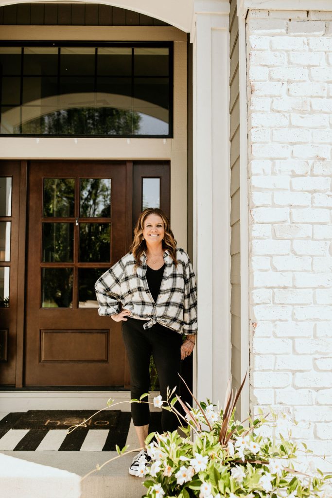 Girl standing on a front porch.