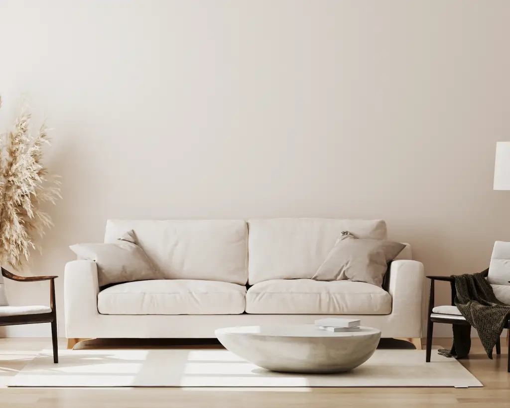All neutral colored room with neutral colored sofa and a round coffee table.