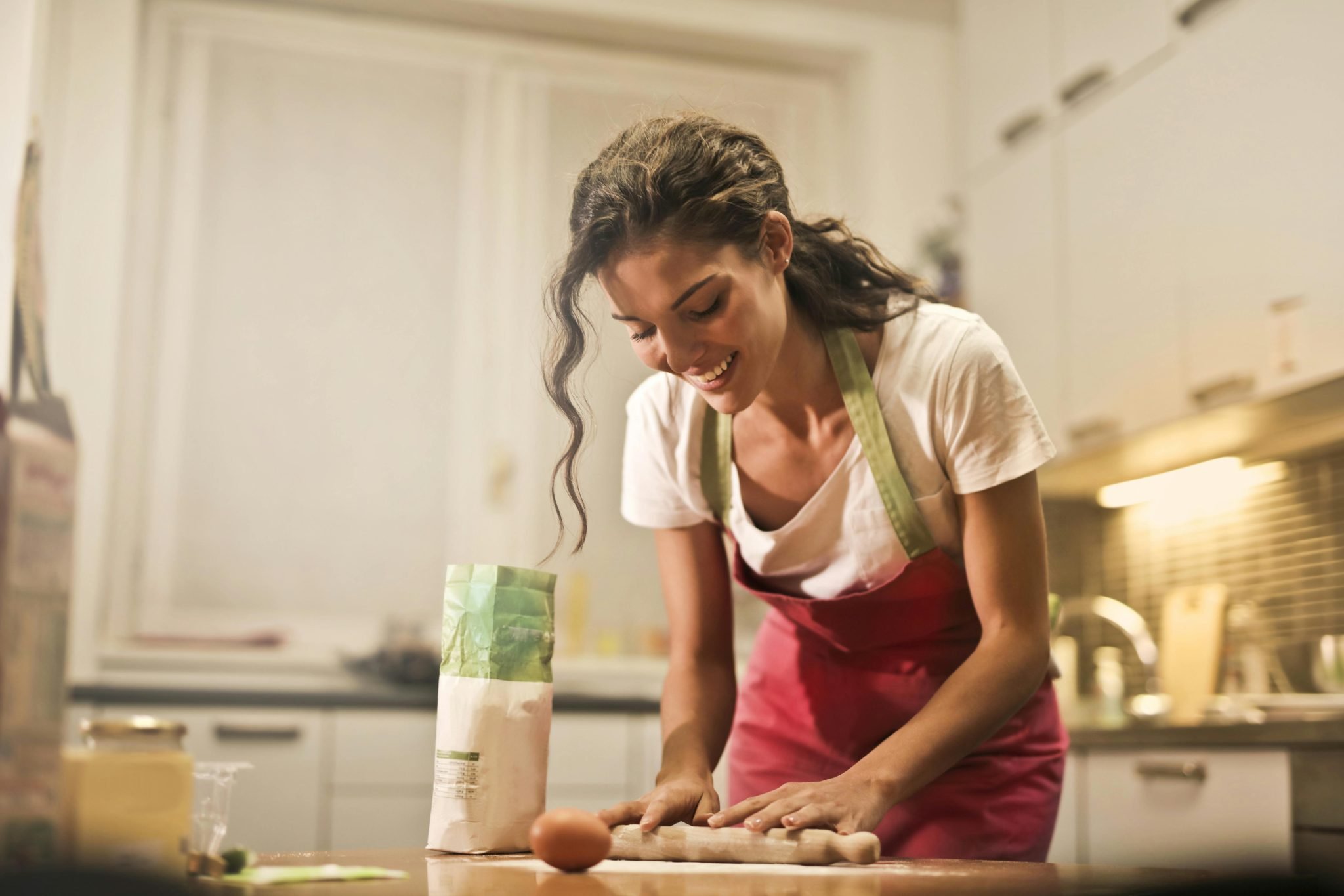 Girl working in a kitchen with a cutting board.